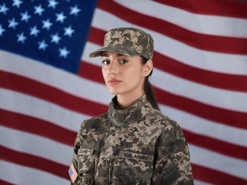 Female American soldier with flag of USA on background. Military service