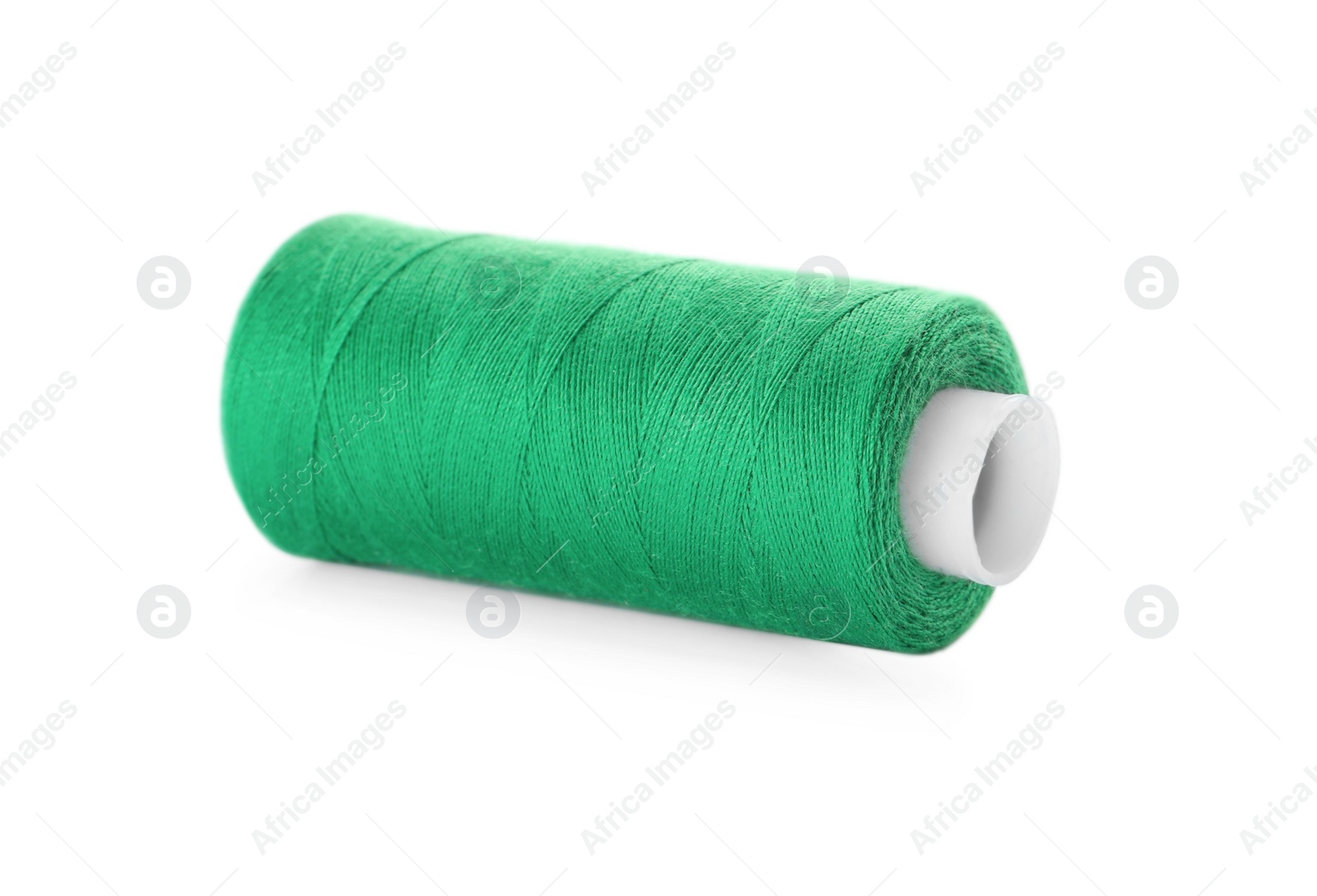 Photo of Spool of green sewing thread isolated on white