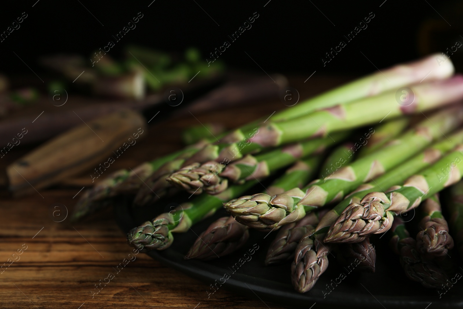 Photo of Fresh raw asparagus on wooden table, closeup