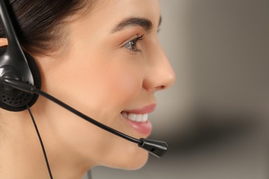 Hotline operator with headset working in office, closeup. Space for text