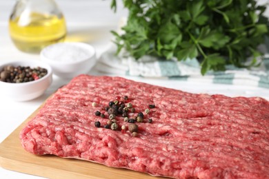 Photo of Raw ground meat, spices, oil and parsley on table, closeup