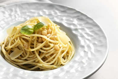 Plate of delicious basil pesto pasta on table, closeup