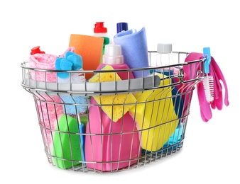 Metal shopping basket with different household chemicals on white background