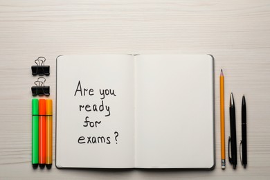 Photo of Notebook with question Are You Ready For Exams? on white wooden table, flat lay