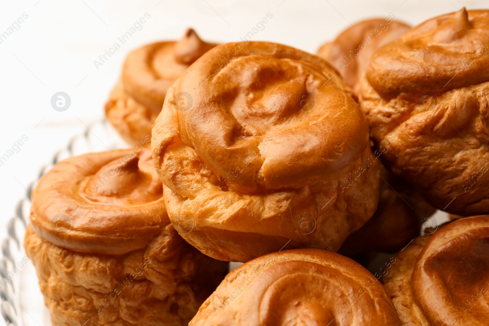 Photo of Delicious profiteroles on white background, closeup view