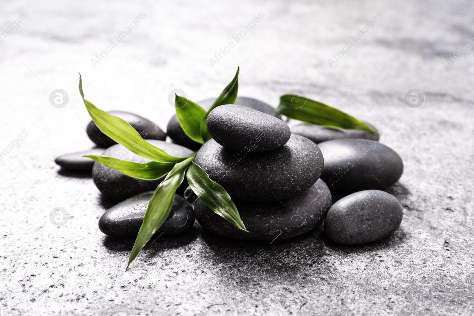 Photo of Spa stones and bamboo sprout on grey table