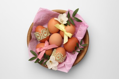 Photo of Easter eggs with colorful bows, twigs and flowers on white background, top view