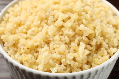 Delicious bulgur in white bowl, closeup view