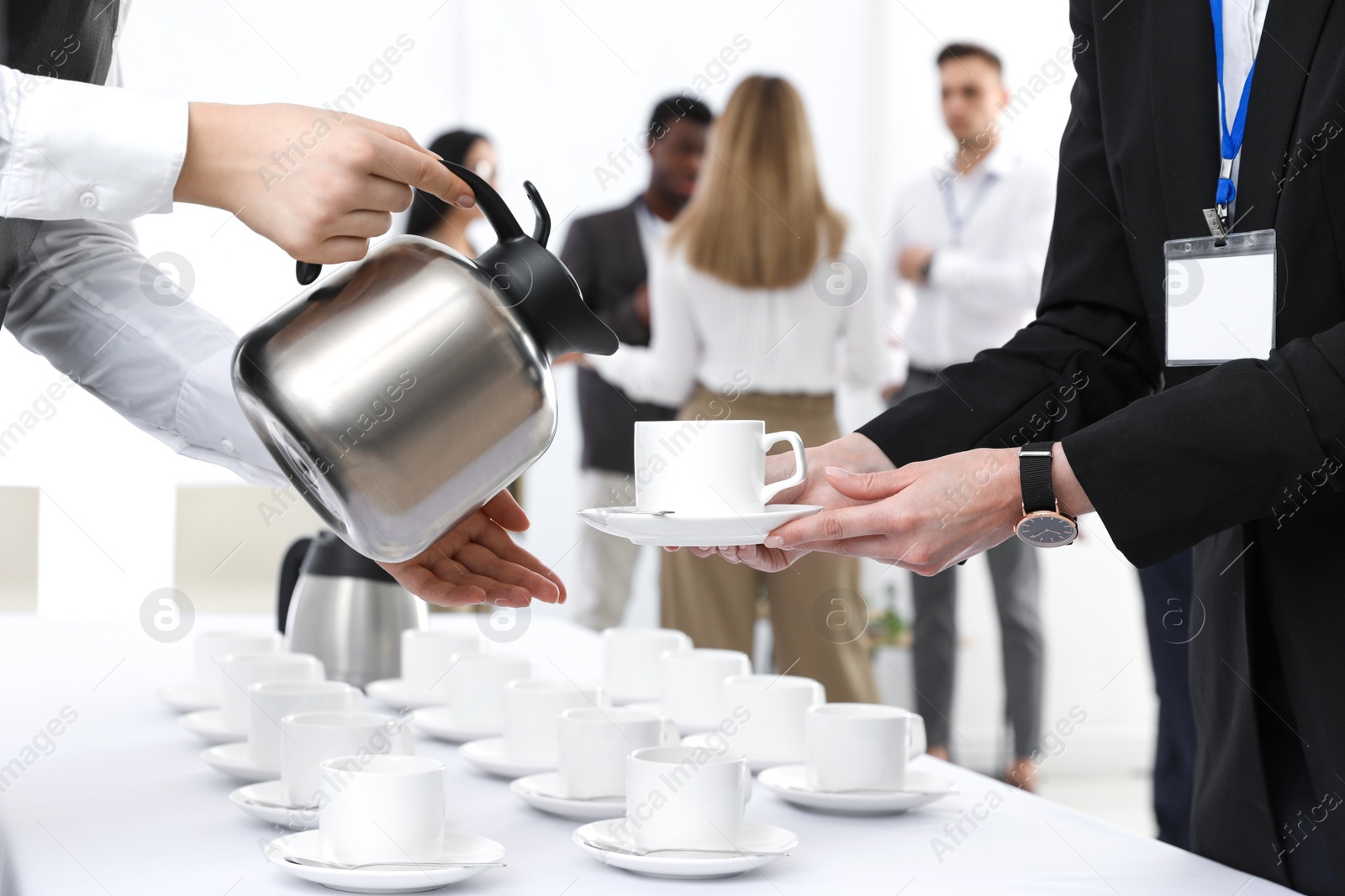 Photo of Waitress pouring hot drink during coffee break, closeup