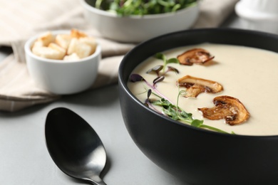 Delicious cream soup with mushrooms on light table, closeup