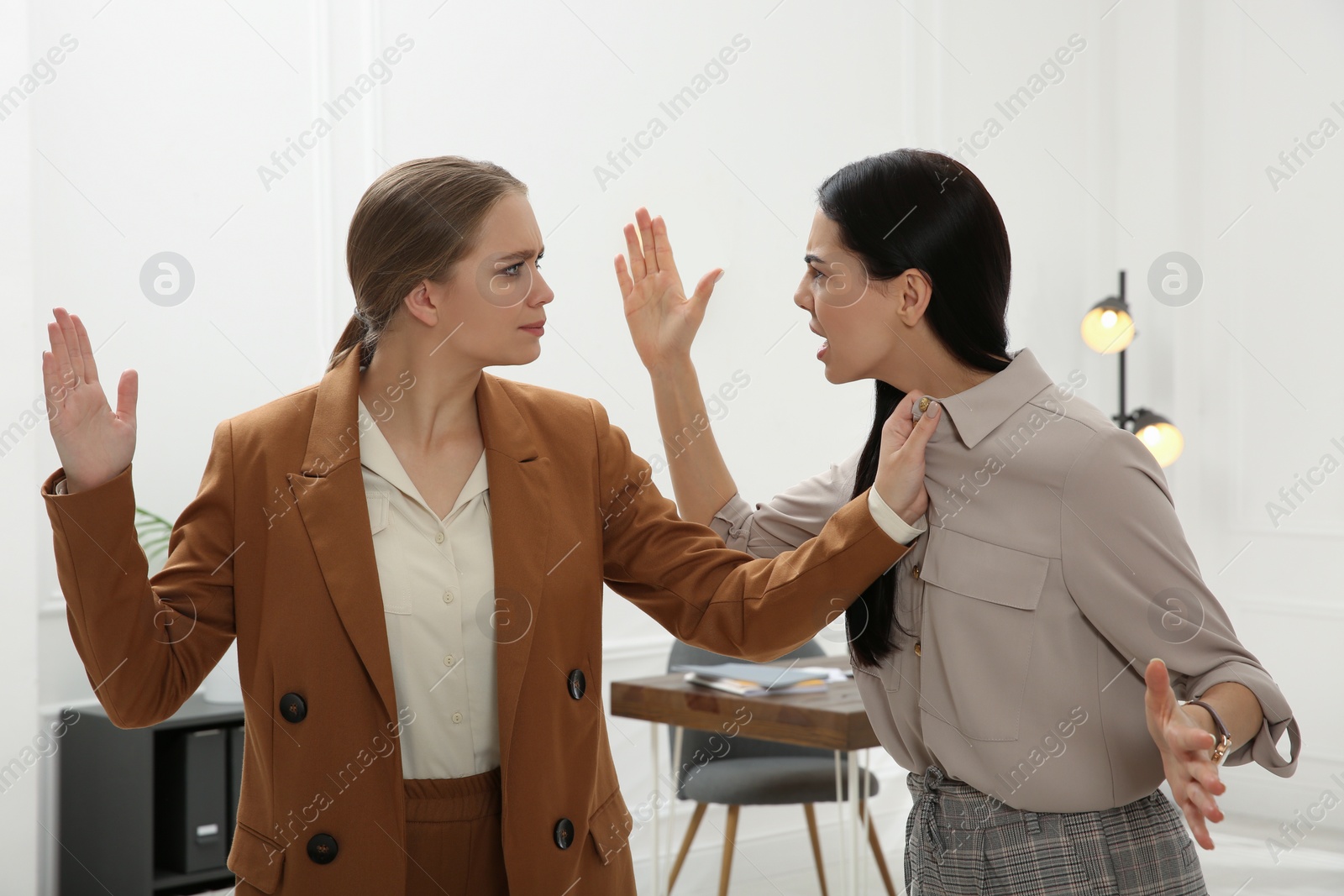 Photo of Emotional colleagues fighting in office. Workplace conflict