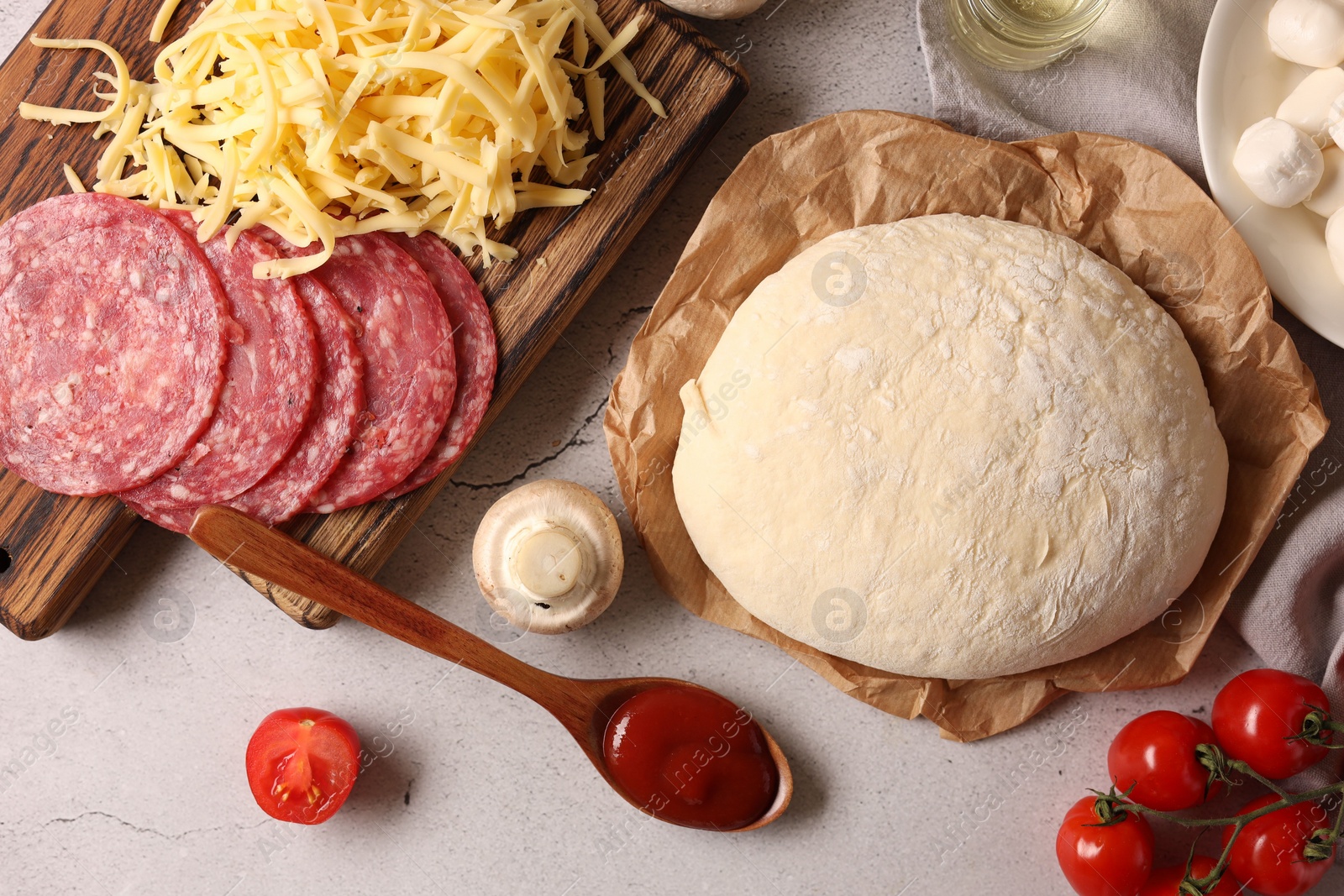 Photo of Pizza dough and products on gray textured table, flat lay