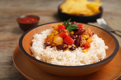 Chili con carne served with rice in bowl on table