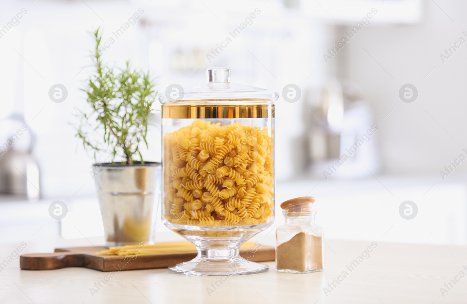 Photo of Raw pasta on wooden table in modern kitchen