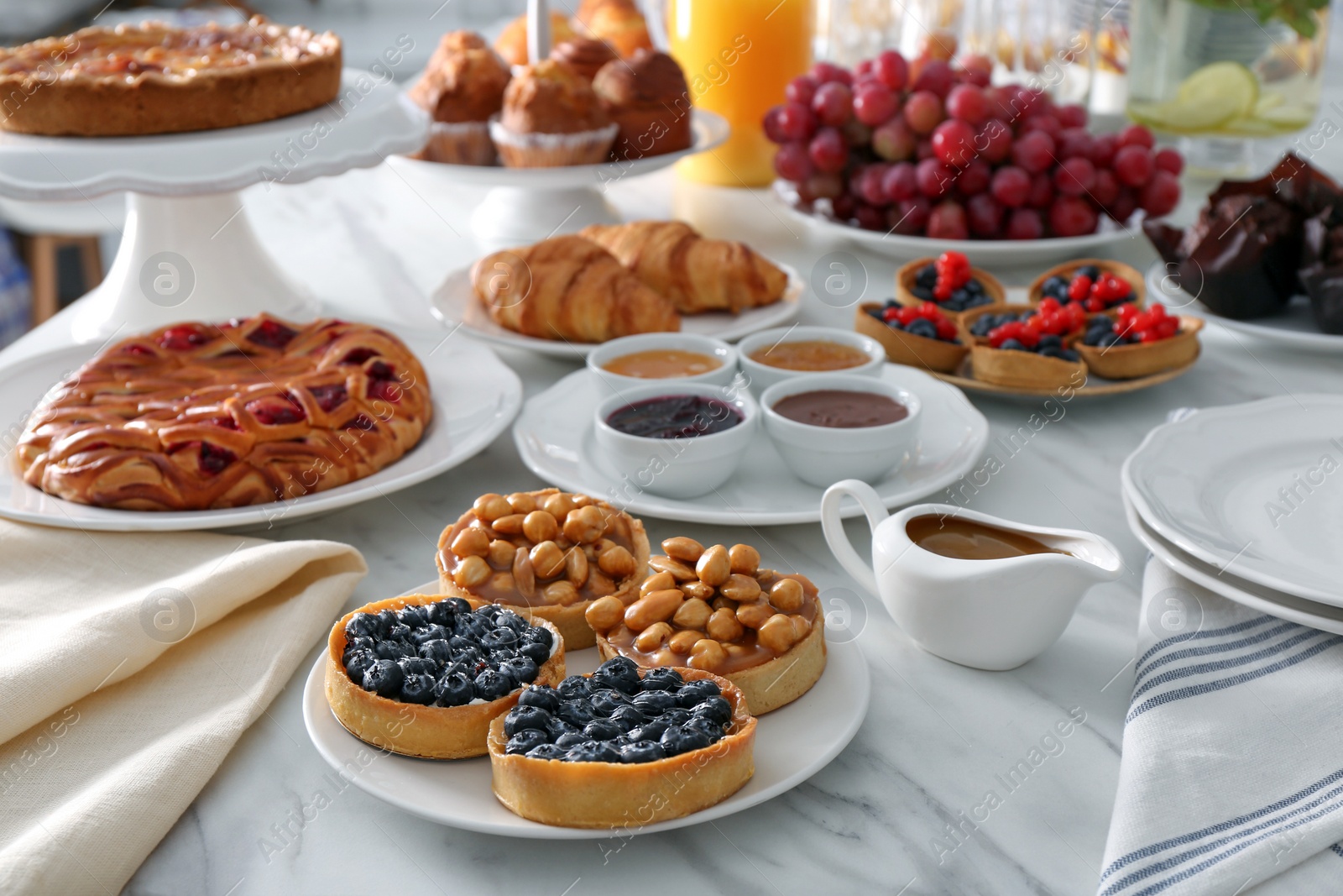 Photo of Variety of snacks on white marble table in buffet style indoors