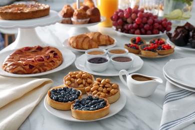 Variety of snacks on white marble table in buffet style indoors