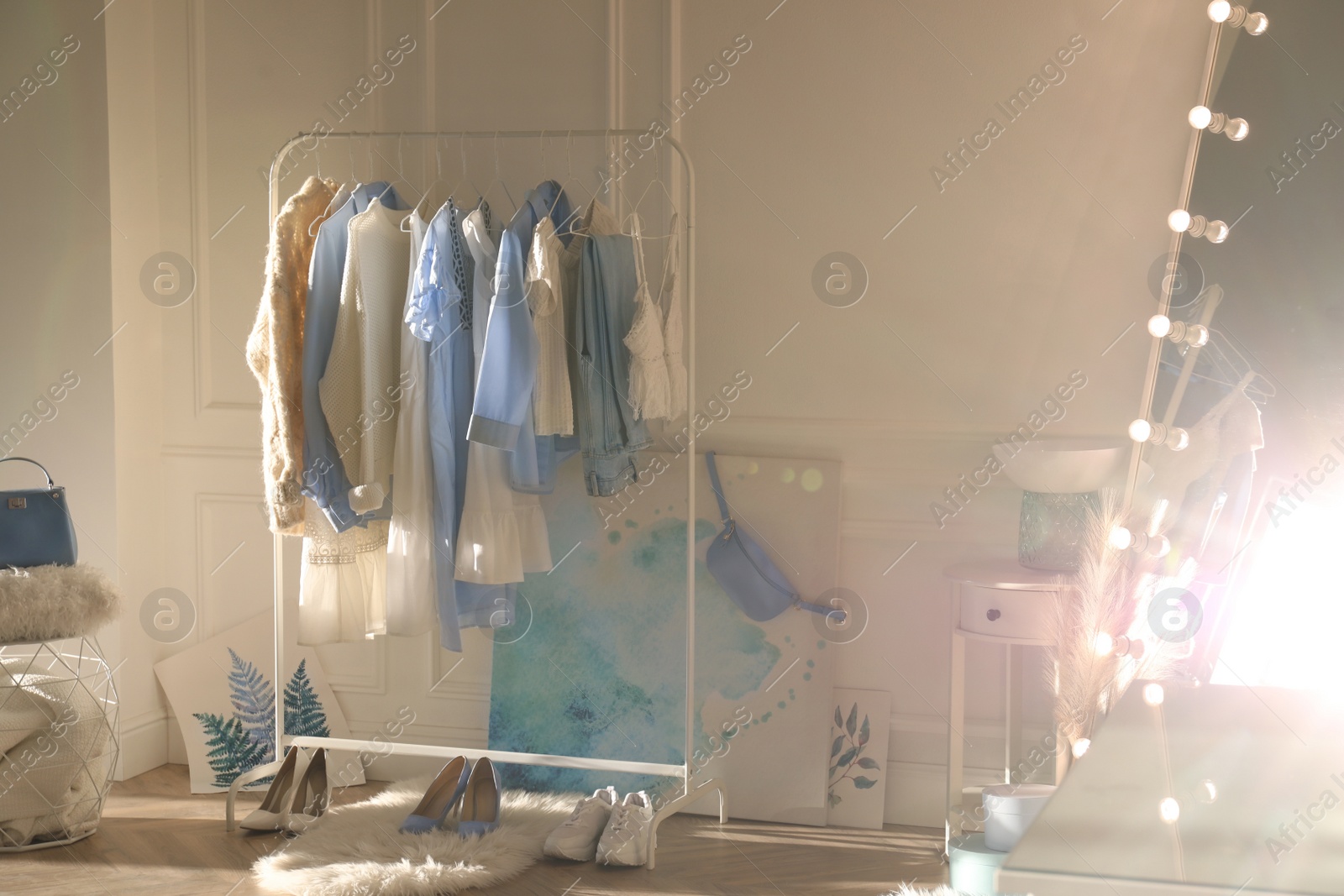 Photo of Rack with stylish women's clothes indoors. Interior design