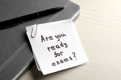 Photo of Note with question Are You Ready For Exams? on white wooden table