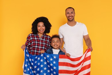 Photo of 4th of July - Independence Day of USA. Happy family with American flag on yellow background