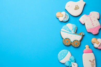 Cute tasty cookies of different shapes on light blue background, flat lay with space for text. Baby shower party
