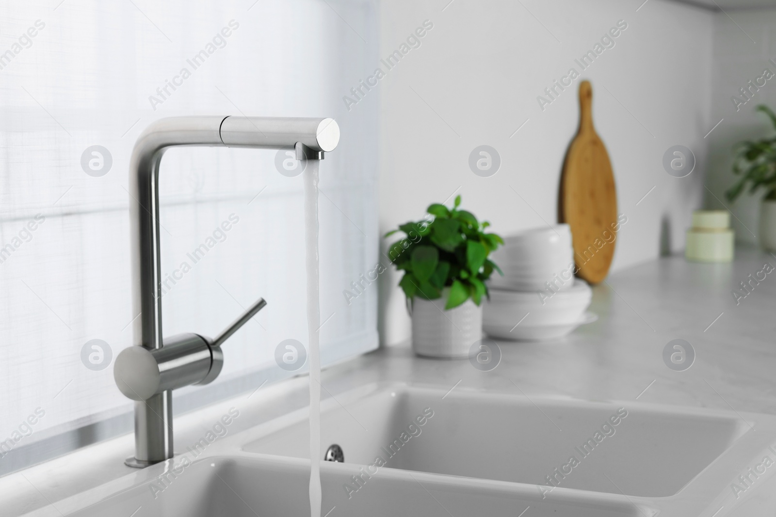 Photo of Stream of water flowing from tap in kitchen, space for text