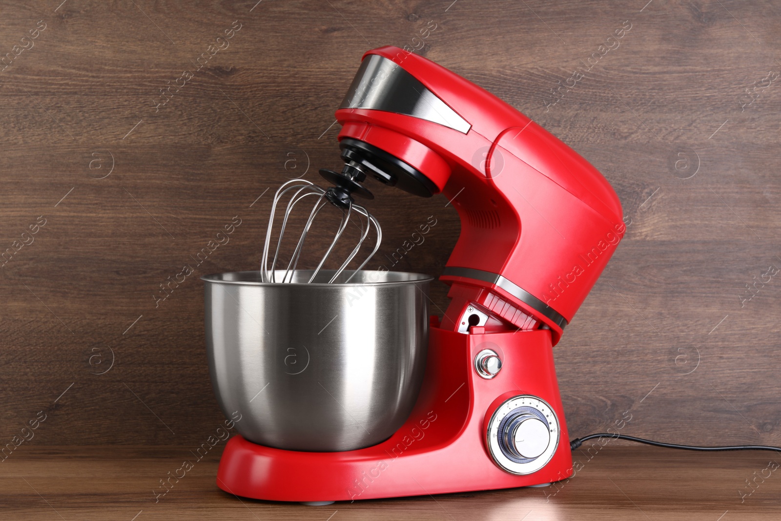 Photo of Modern red stand mixer on wooden table