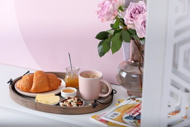 Photo of Tray with tasty breakfast on white table in morning. Space for text