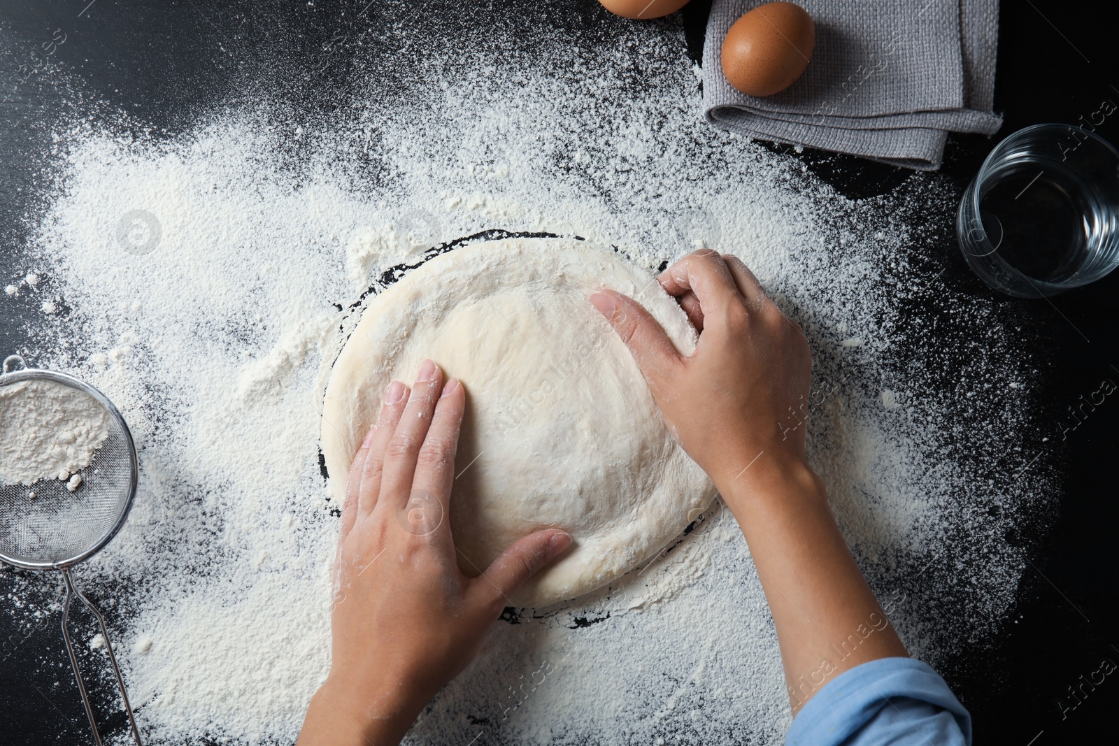 Photo of Woman making dough for pastry on table