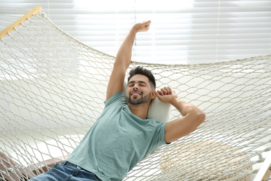 Young man relaxing in hammock at home