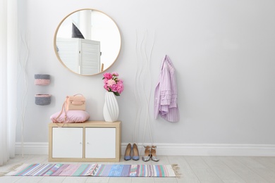 Photo of Stylish hallway interior with round mirror on white wall