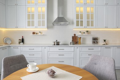 Photo of Elegant kitchen interior with stylish furniture and modern stove