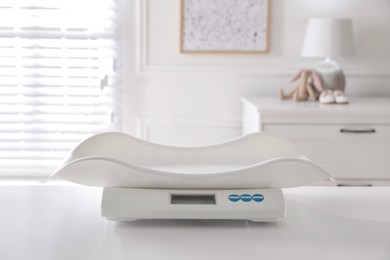 Photo of Modern digital baby scales on table in room