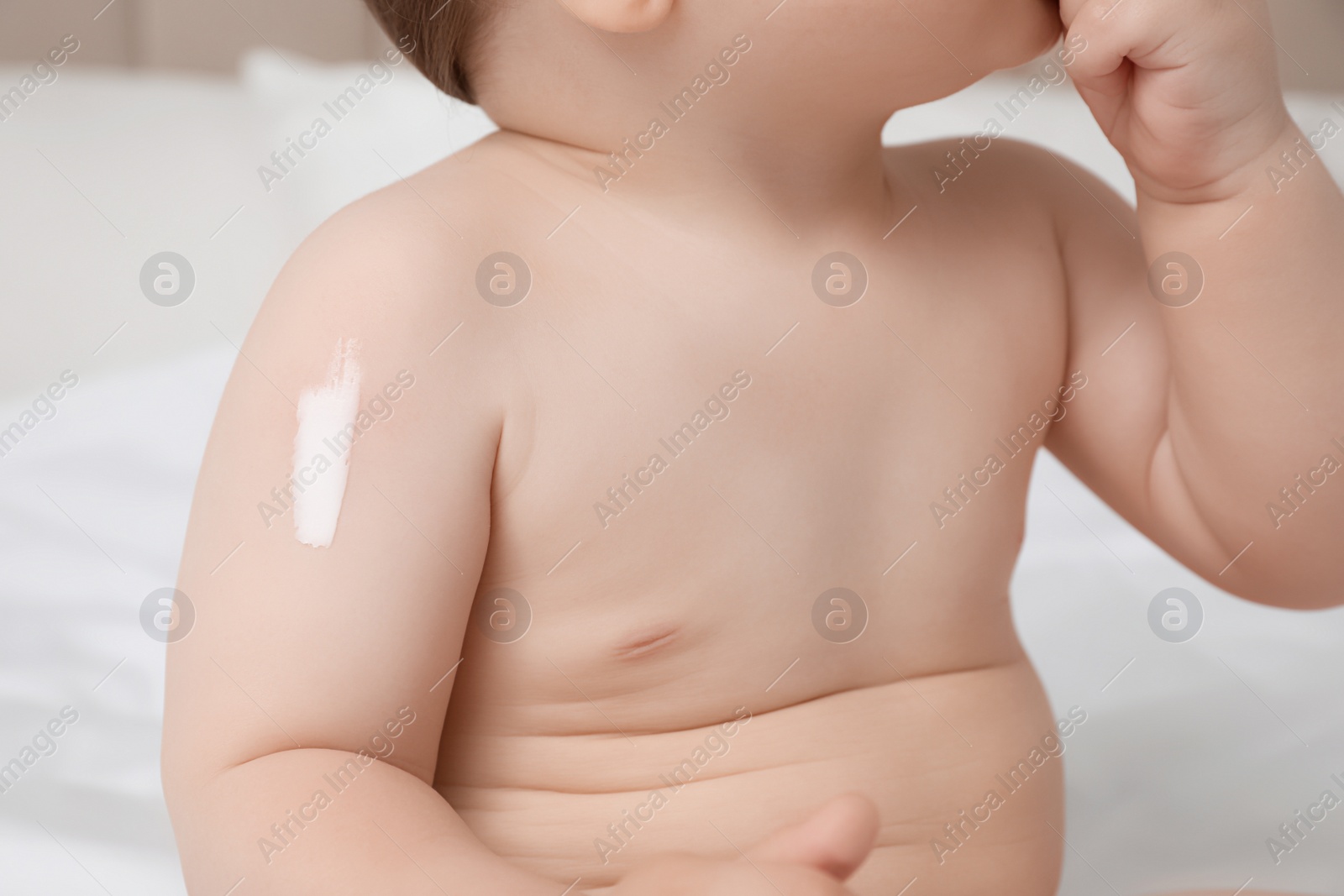 Photo of Cute little baby with cream on arm, closeup