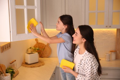 Photo of Mother and daughter cleaning up kitchen together at home