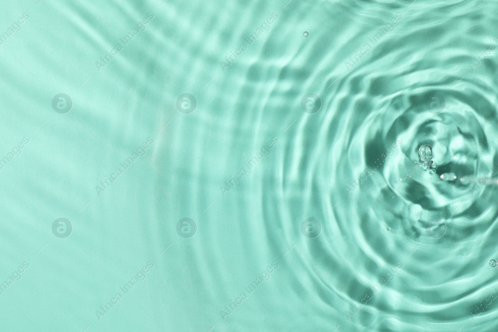 Photo of Closeup view of water with rippled surface on light blue background