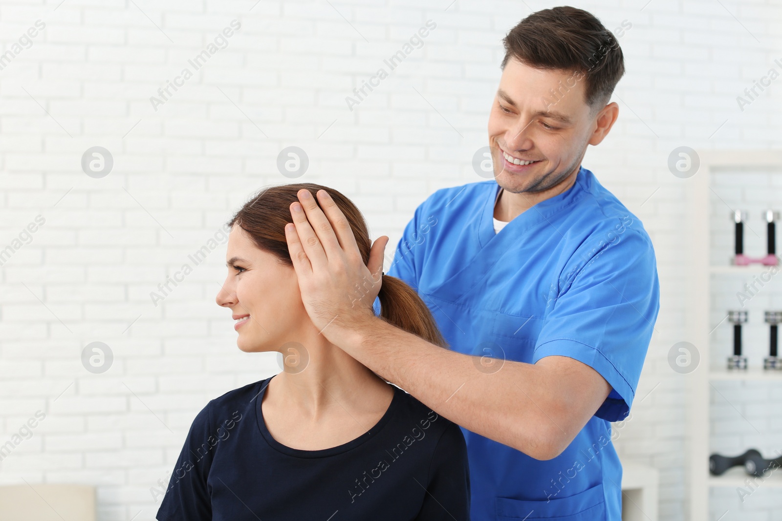 Photo of Physiotherapist working with patient in clinic. Rehabilitation therapy