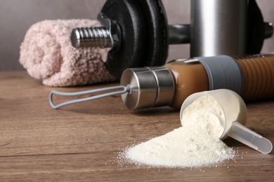 Photo of Composition with measuring scoop of protein powder on wooden table