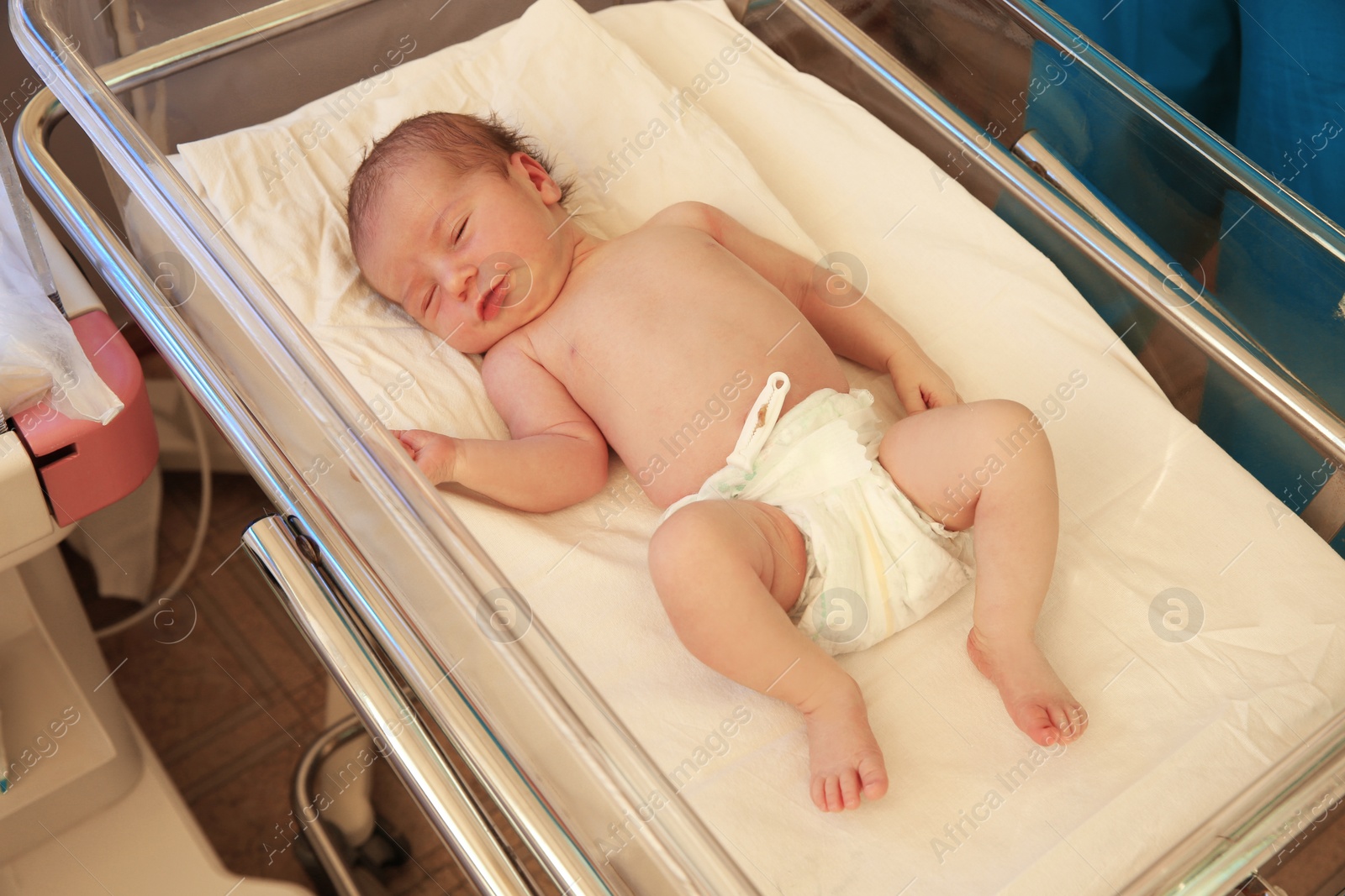 Photo of Newborn child sleeping on bed in hospital