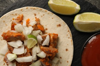 Photo of Delicious taco with vegetables, meat and ketchup on grey table, top view