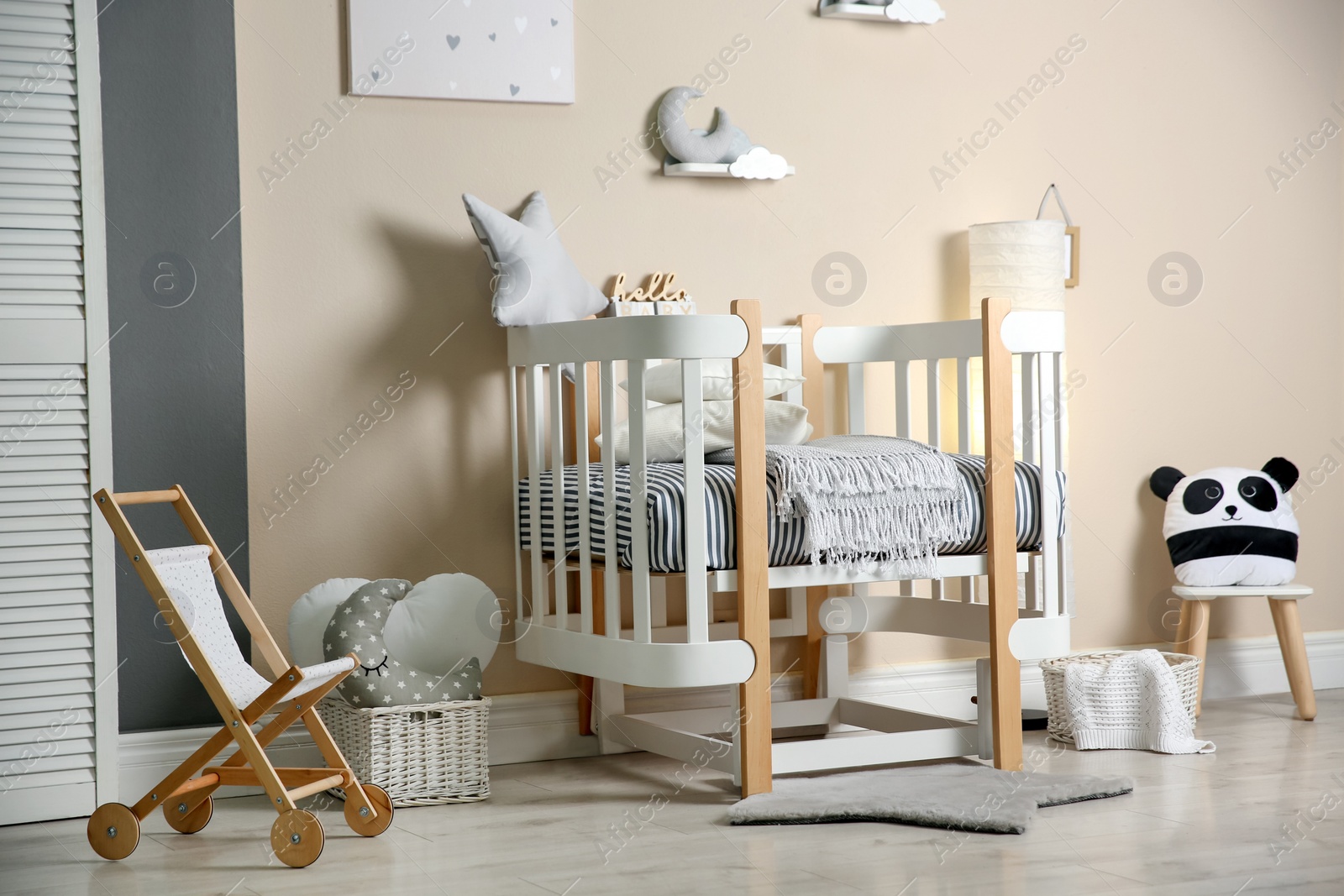 Photo of Cute baby room interior with modern crib and toys