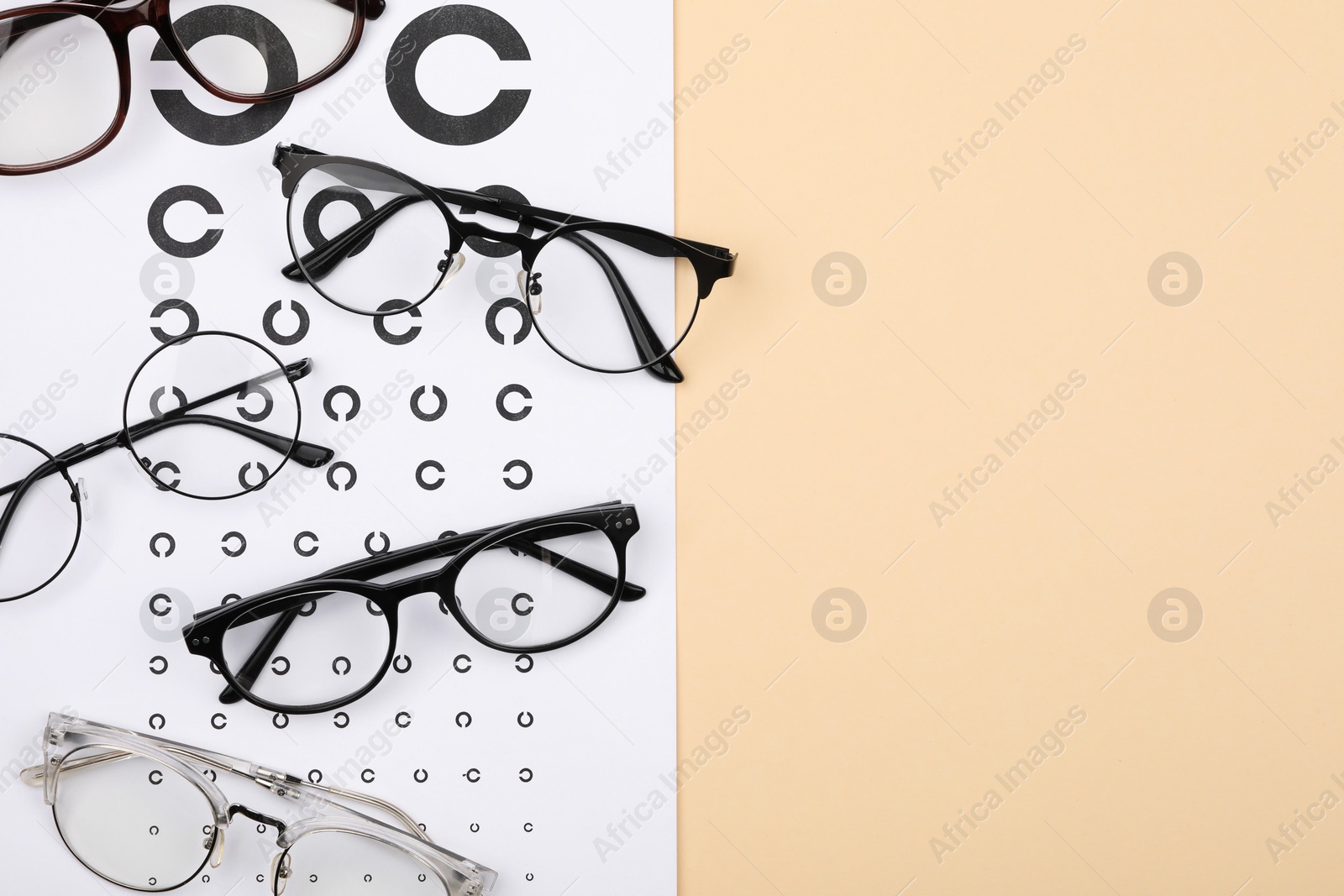 Photo of Vision test chart and glasses on beige background, flat lay. Space for text