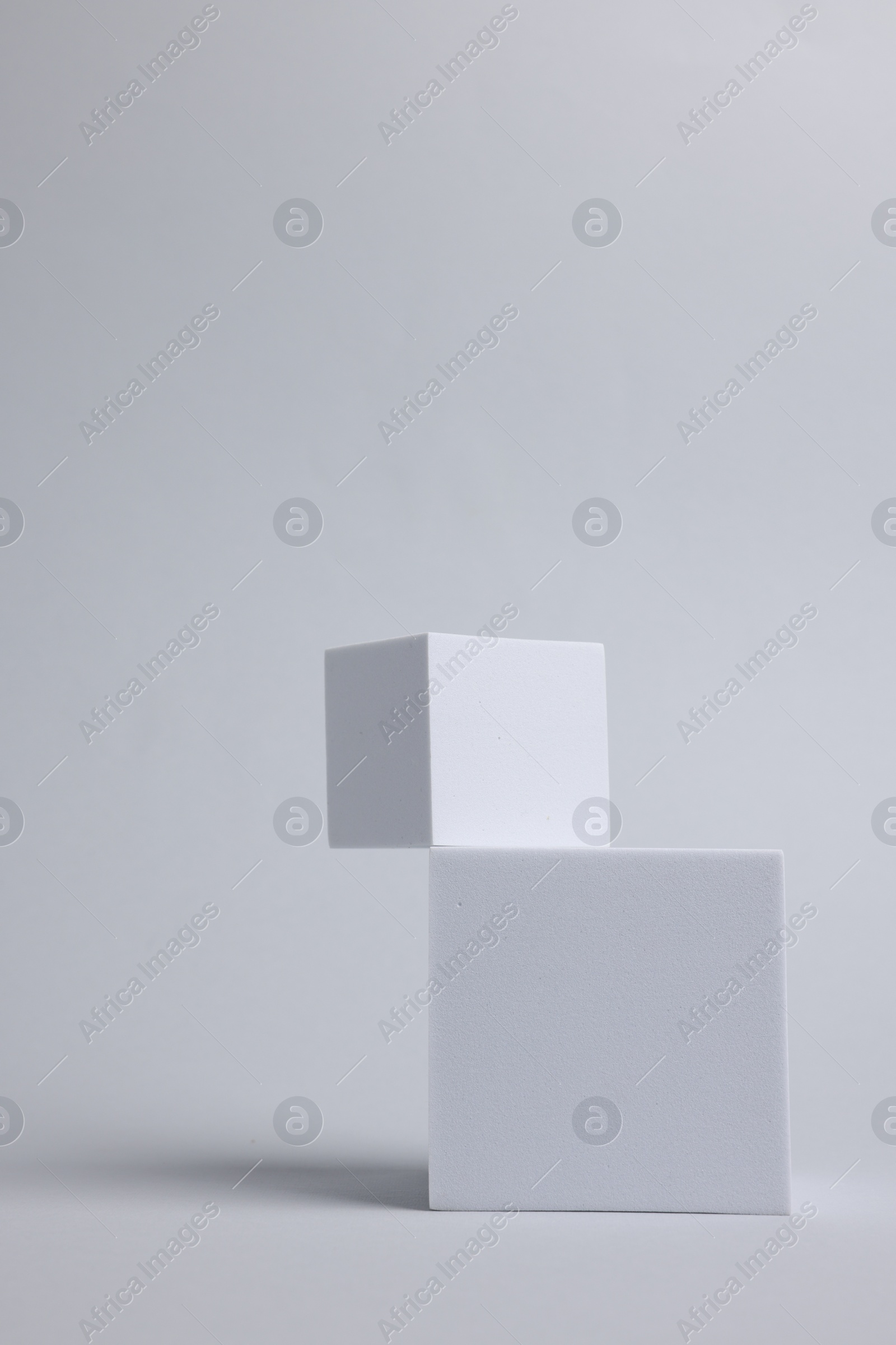 Photo of Scene with podium for product presentation. Cubes on light grey background