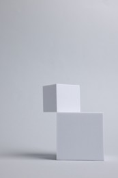Photo of Scene with podium for product presentation. Cubes on light grey background