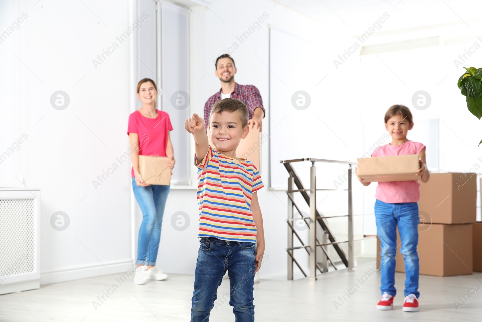 Photo of Happy family with moving boxes in their new house