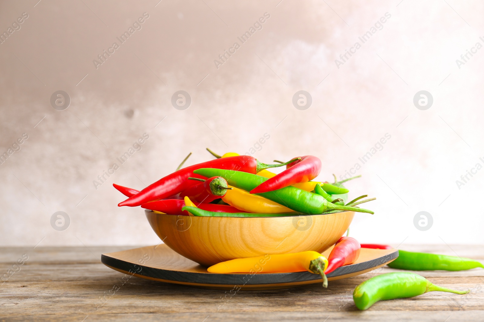 Photo of Dishware with ripe chili peppers on table