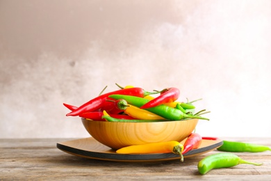 Photo of Dishware with ripe chili peppers on table