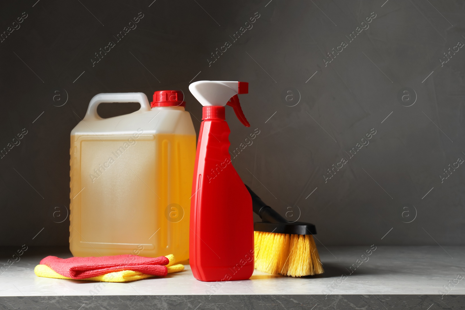 Photo of Car cleaning products and canister with motor oil on light grey table. Space for text