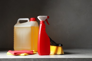 Photo of Car cleaning products and canister with motor oil on light grey table. Space for text
