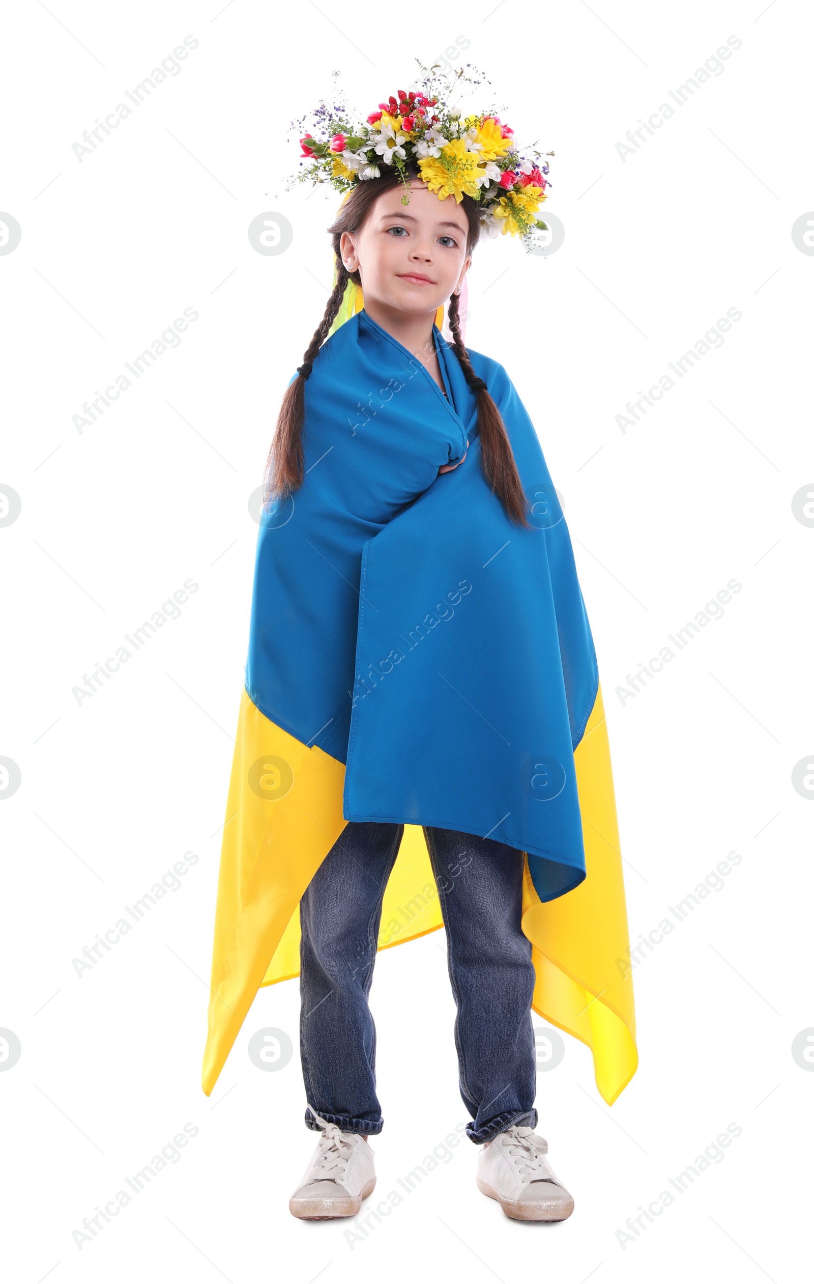 Photo of Little girl in flower wreath with flag of Ukraine on white background