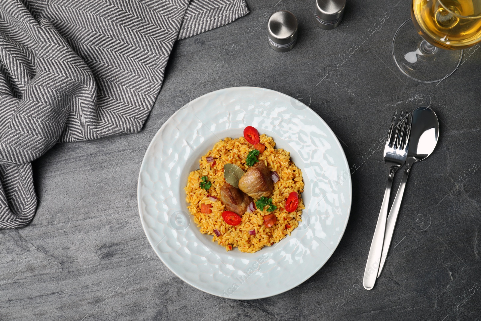 Photo of Plate with rice pilaf and meat on grey background, flat lay